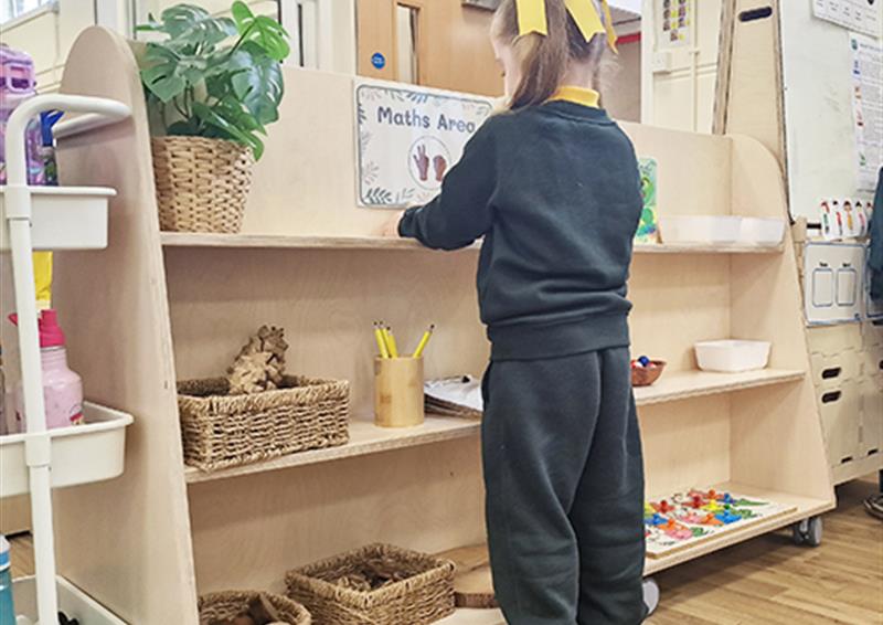 School child organizing shelves