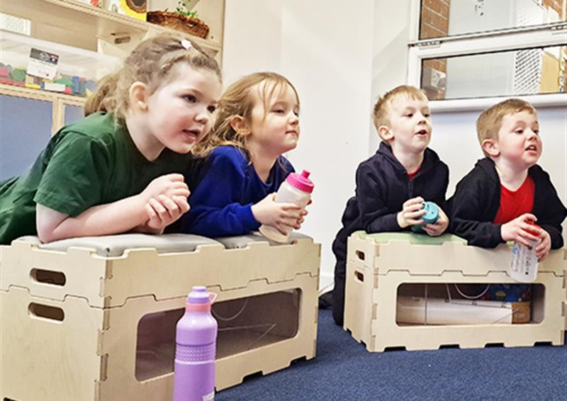 School children leaning on Stack and Sit Benches.