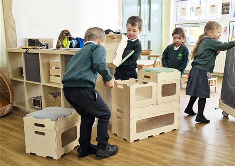 School children rearranging Stack and Sit Stools.