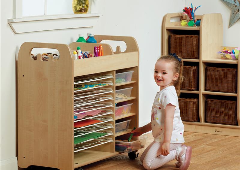 A young girl selecting arts and crafts supplies from the Combi Art Trolley, in a classroom.    