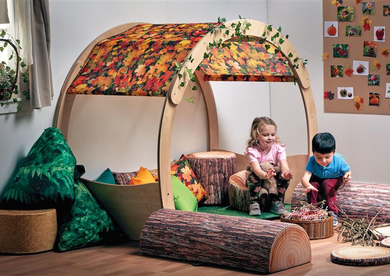 A young girl and boy are playing inside the Large Cosy Cove Plus Autumn Accessory Set in a classroom.