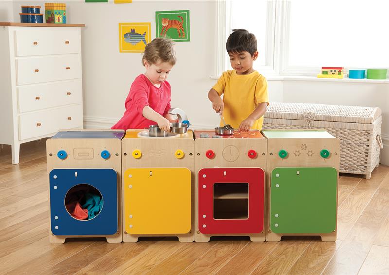 A young boy and girl are playing with the Wolds Kitchen Set (Sink, Washer, Cooker & Fridge), inside a classroom.