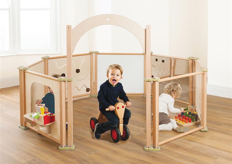The Toddler Play Panel Starter Set - Enclosure 8 Panel Set has been set up in a classroom with three young children playing inside the enclosure. 