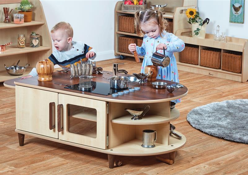 Two toddlers are playing role play games using the Island Kitchen.