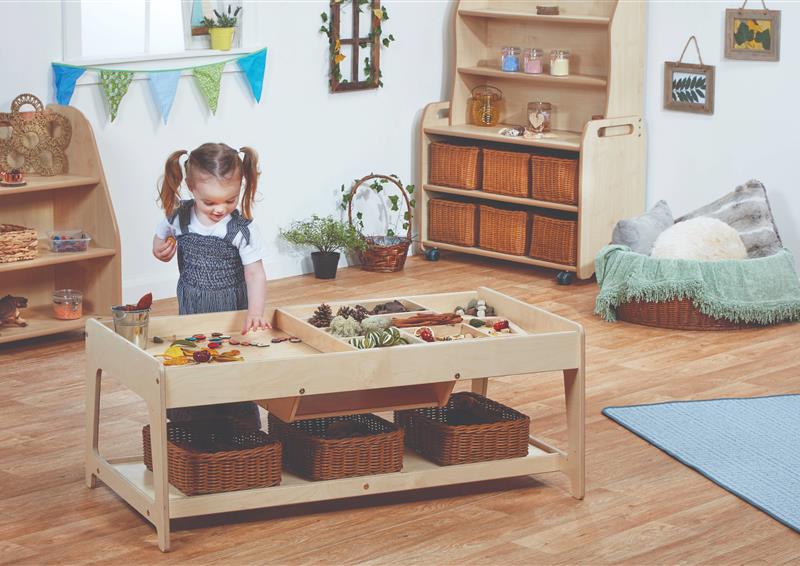 A young girl sorting different small world resources on an Investigative Play Table with 4 Baskets, in a classroom
