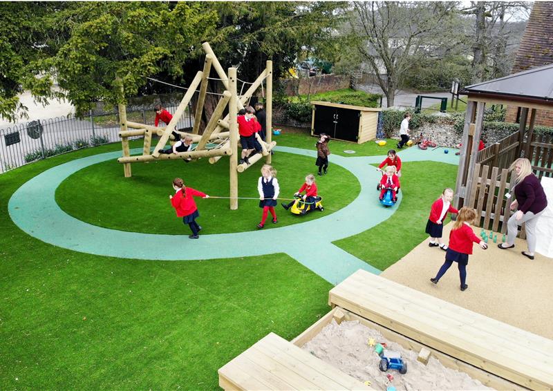 primary school children in key stage 1 playing outside with climbing frame