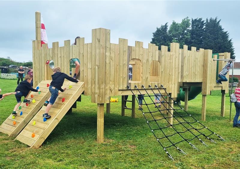 children playing on large wooden play tower