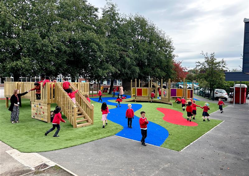 A busy school playground with a tower and colourful flooring.